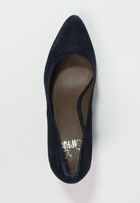 Decolleté in suede blu navy con punta affusolata, apertura elastica e interno liscio marrone con logo. Suola piatta per un facile utilizzo.