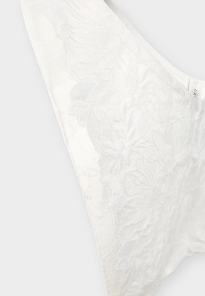 Tissu en dentelle blanche avec des détails de broderie florale sur un fond transparent, montrant une texture complexe et des coutures délicates.