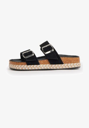 Sandale mule en daim noir avec deux brides à boucle argentée, semelle plateforme en liège et bordure en jute tissée le long du bord.