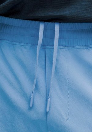 Light blue athletic shorts with an elastic waistband, drawstring, and a smooth texture. Features stitching details and a relaxed fit.