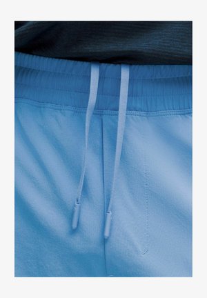 Svetlomodré športové kraťasy s elastickým pásom, šnúrkou na sťahovanie a hladkým povrchom. Obsahujú detaily stehov a uvoľnený strih.
