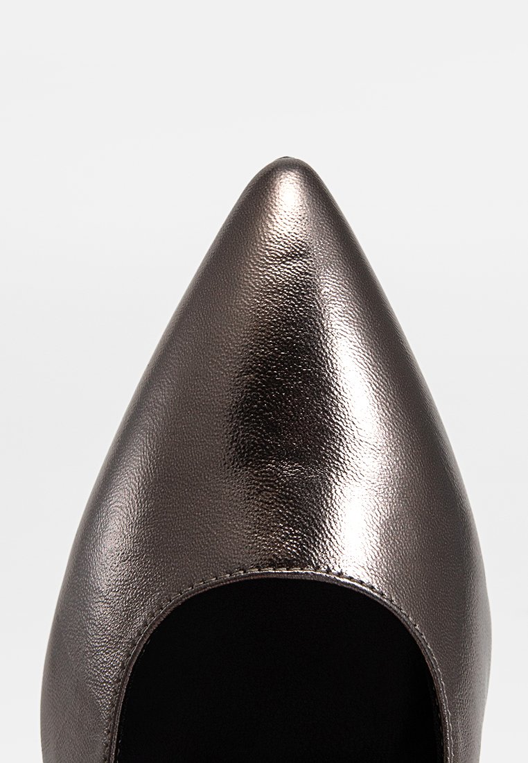 Chaussure à bout pointu en cuir bronze métallisé avec une texture lisse, offrant un côté ouvert et un intérieur noir.