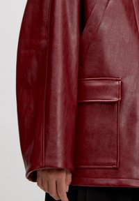 Rode nepleder jack met een relaxte fit, textuur oppervlak, oversized mouwen en een patchzak aan de voorkant.
