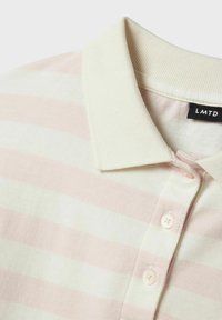 Polo a righe in morbido rosa pastello e bianco, in cotone, con colletto e patta con tre bottoni, con un'etichetta che riporta "LMTD."