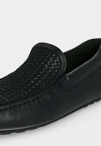 Μαύρο δερμάτινο λόφερ με υφασμένη υφή στο επάνω μέρος, ραφή μοκασίνου και χαμηλής προφίλ σόλα από καουτσούκ.