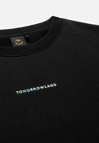 Zwarte sweatshirt met geribbelde halslijn, voorzien van een iriserend "TOMORROWLAND" logo dat in een modern lettertype op de borst is gestikt.