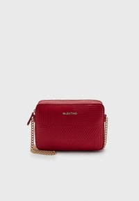 Bolso cruzado de cuero acolchado Red Valentino con correa de cadena dorada y cierre de cremallera sobre fondo liso.