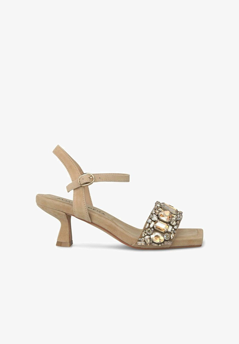 Sandale à talon en suède beige avec une bride de cheville, un bout carré et des détails en strass sur le devant. Design à petit talon carré.