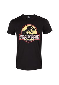 Černé bavlněné tričko s kulatým logem a grafikou dinosaura, na kterém je text "Jurský park" v červené a bílé barvě. Krátké rukávy, klasický střih.