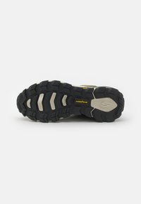 Traction outsole of hiking shoe featuring rugged, multi-directional lugs, grey and black rubber with Goodyear branding and textured accents.