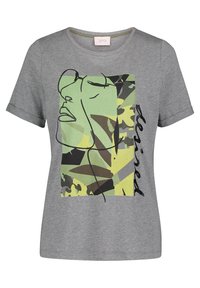 Camiseta gris de manga corta con arte lineal abstracto de cara en verde y amarillo y patrón de camuflaje, que presenta la palabra "reservado" de manera vertical.
