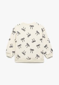 Creme sweatshirt med et mønster af sorte sløjfer. Fremstillet af blødt stof, har den rund hals og elastiske manchetter med en afslappet pasform.