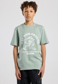 Light green cotton t-shirt with a round neckline, short sleeves, and a white graphic featuring a cartoon broccoli and text.