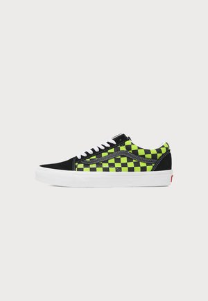 Niskie sneakersy z czarno-neonowo zielonym wzorem w kratkę, białymi sznurowadłami i białą gumową podeszwą na jednolitym jasnym tle.