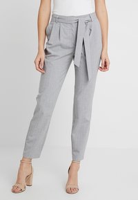 Světle šedé kalhoty na míru s vertikálními proužky, plissé přední částí a opaskem. Vyrobené z hladké tkaniny s tapered nohavicemi.