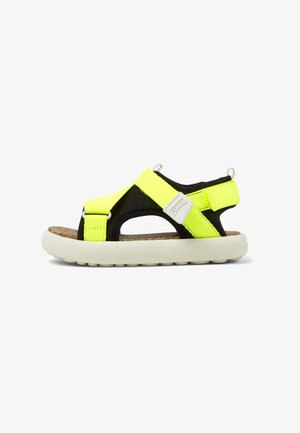 Schwarze und neon-gelbe Sandale mit verstellbaren Riemen, Korkfußbett und einer weißen Gummisohle mit strukturiertem Boden für Grip.