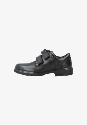 Chaussure habillée en cuir noir avec deux brides réglables en Velcro et un talon bas, vue du côté extérieur.