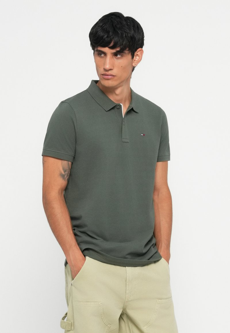 Olijfgroene polo met een klassieke kraag, korte mouwen en een klein logo op de borst. Zachte textuur en slim fit ontwerp.