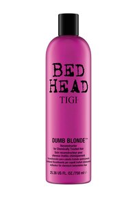 Vaaleanpunainen muovipullo, jossa on musta korkki, etiketti "BED HEAD TIGI DUMB BLONDE." Tekstissä on tuotedetaljeja englanniksi ja useilla muilla kielillä.