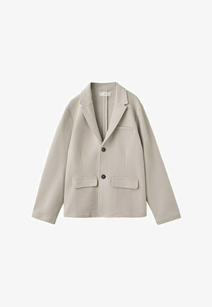 Bež enodelni blazer z dvema črnima gumboma, z razrezanimi ovratniki, sprednjimi žepki s preklopom in prsnim žepkom, prikazan na belem ozadju.