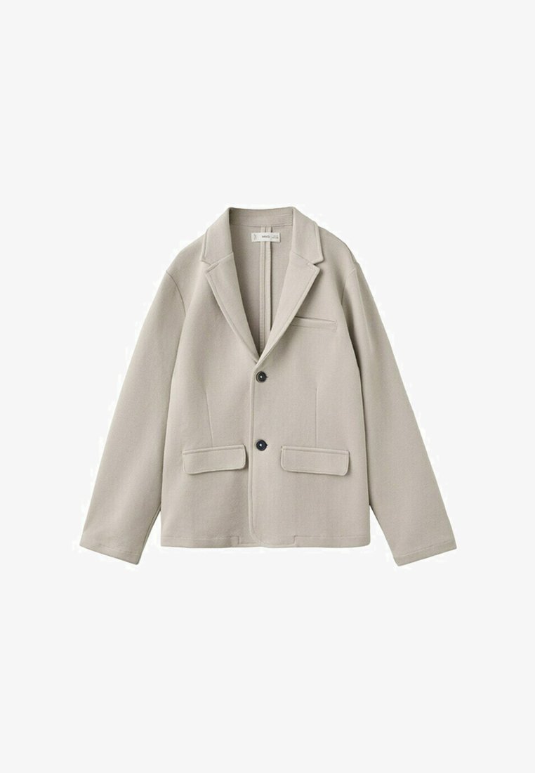 Bež enodelni blazer z dvema črnima gumboma, z razrezanimi ovratniki, sprednjimi žepki s preklopom in prsnim žepkom, prikazan na belem ozadju.