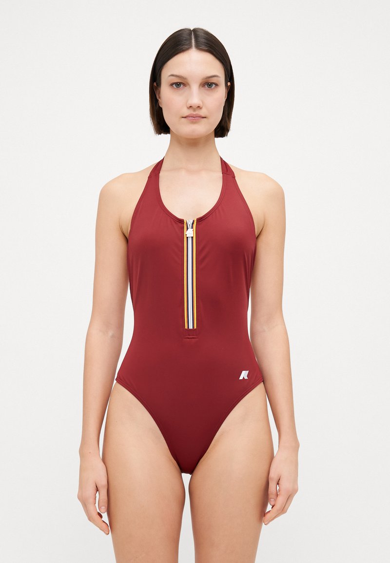 Bodysuit merun dengan ritsleting depan yang menampilkan garis berwarna-warni. Dirancang dengan leher halter dan aksen logo di pinggul.