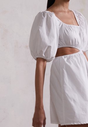 Vestido corto blanco con mangas abullonadas y escote cuadrado, que presenta un corte en la cintura y un detalle elástico fruncido para un ajuste ceñido.