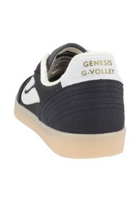 Sneaker mit einem schwarzen Canvas-Obermaterial, weißen Akzenten und einer strukturierten Wildlederschnalle. Goldene Prägung "GENESIS G-VOLLEY" auf der Rückseite. Gummisohle.