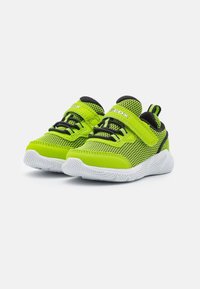 Zapatillas de niño pequeñas en verde brillante y negro, con suelas texturizadas blancas, parte superior de malla, correas de velcro y cordones elásticos para poner y quitar fácilmente.