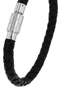 Pulsera trenzada de cuero negro que presenta un cierre decorativo de plata con patrones florales grabados y un acabado pulido.