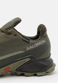 Męskie buty do biegania po szlakach marki Salomon w oliwkowej zieleni, z teksturowanym wierzchem, czarną podeszwą i brandingiem GORE-TEX po boku.