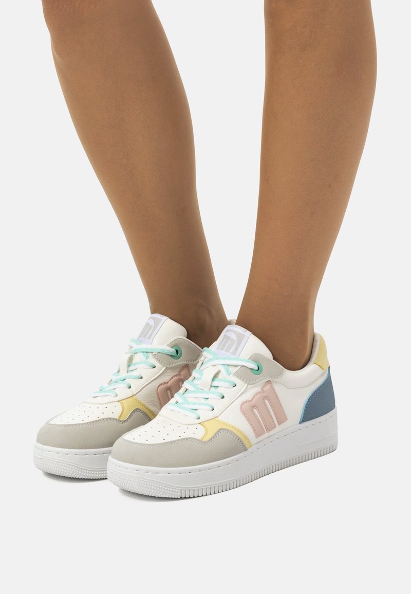 Weiße Sneakers mit pastellfarbenen Akzenten in Blau, Rosa und Gelb. Merkmale sind eine perforierte Zehenpartie, runde Schnürsenkel und eine strukturierte Sohle.