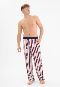Rood en witte gestreepte pyjamabroek met een blauwe elastische tailleband, versierd met blauwe vispatronen. Lichtgewicht stof, comfortabele pasvorm.