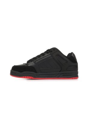 Zapatilla baja negra con suela exterior de goma roja y cordones negros, con cuello acolchado y diseño de paneles cosidos en el lateral.