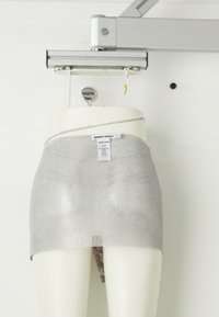 Zilveren mesh mini-rok met een aansluitend ontwerp, voorzien van een kettingdetail bij de taille. Het materiaal lijkt reflecterend en heeft een gestructureerd oppervlakte.