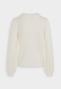 Krämfärgad stickad tröja med ribbad krage och texturerade, puffärmar. Har en slät kropp och intrikata spetsmönster på ärmarna.