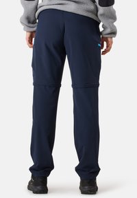 Navy blue outdoor pants made of stretchy fabric, featuring side pockets and a relaxed fit, with a smooth texture and adjustable hem.