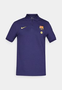 Navy blue polo shirt with short sleeves, made of cotton. Features Nike logo in gold, FC Barcelona crest, and a Spotify logo in white.