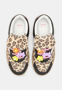Baskets en imprimé léopard avec des accents noirs, ornées de fleurs en plastique décoratives colorées et de nœuds sur les lacets, fabriquées en véritable cuir.