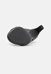 Black high-heeled shoe with a smooth, curved sole, open toe design, and decorative straps. Matte finish with a subtle textured pattern.