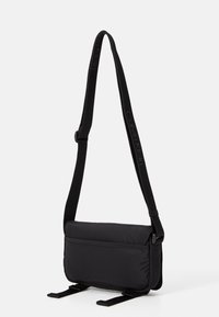 Svart nylon crossover-veske med justerbar stropp, flat rektangulær form, glatt tekstur og lomme med glidelås foran. Akkompenert med merkevare.