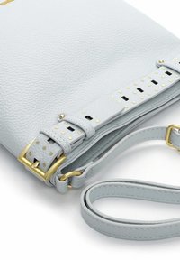Hellgraue Leder-Umhängetasche mit strukturierter Oberfläche, goldfarbenen Beschlägen und mit Nieten besetztem Riemen. Verstellbarer Schulterriemen inklusive.