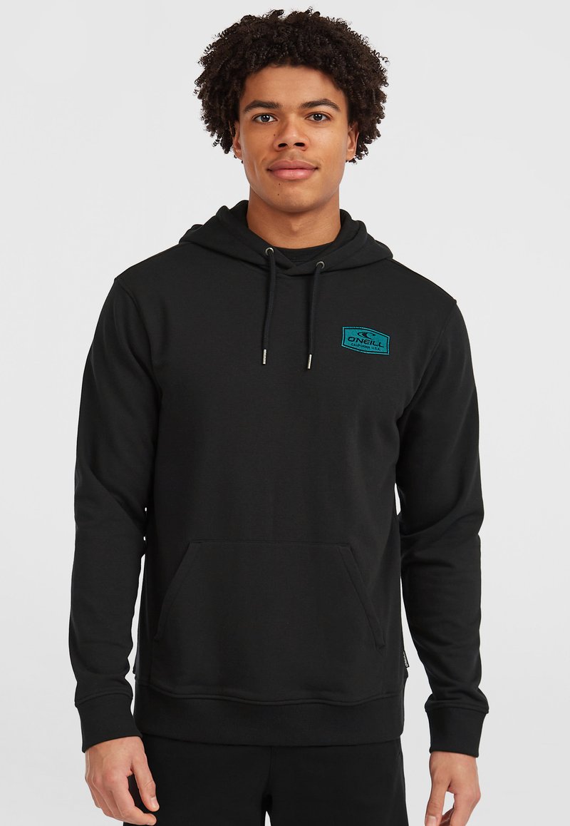 Schwarzer Hoodie aus weichem Stoff, mit einer Vordertasche, verstellbarem Kordelzug an der Kapuze und einem blauen Logo-Patch auf der Brust.