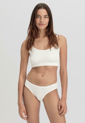 Weiße Baumwoll-Bralette und passende Slips, die ein schlichtes Design mit dünnen Trägern, einer glatten Textur und ohne auffällige Muster oder Verzierungen aufweisen.