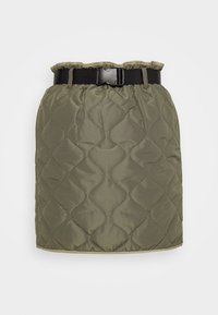 Jupe matelassée en vert olive foncé avec une ceinture noire. Dispose d'une taille froncée et d'un motif texturé en vagues sur le tissu.