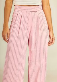 Roze wijde broek met verticale zilveren strepen, geplooid ontwerp en een tailleband, gemaakt van een gladde stof. Voorzien van zijzakken.