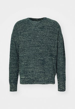 Tummanvihreä ja musta meleerattu neulottu pyöreäkauluksinen neulepaita, jossa pitkät hihat ja hieman väljä istuvuus.