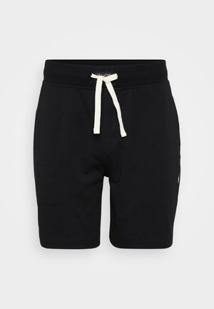 Shorts en coton noir avec une taille élastique, un cordon de serrage crème et un accent logo sur le côté. Texture douce et lisse. Longueur mi-cuisse.
