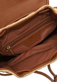 Interno di borsa in pelle marrone con una tasca con cerniera, fodera marrone e un dettaglio intrecciato in paglia. Pelle lavorata e tessuto liscio.