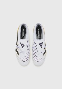 White athletic shoes with purple and black accents; textured upper with wavy patterns, slip-on design, and padded collar.